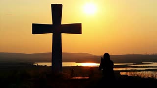 silhouette-of-man-praying-under-the-cross-at-sunset-sunsrise_4kpkhgsr__S0000